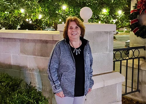 Woman standing in front of a low marble wall